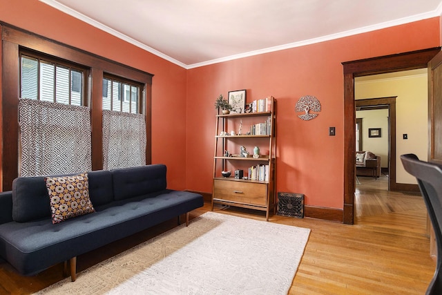 living room featuring light wood finished floors, baseboards, and crown molding
