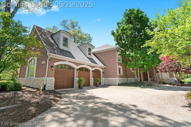 4563 Haverhill, Commerce Twp, MI 48382 - view of front of home with stone siding, a garage, concrete driveway, and brick siding