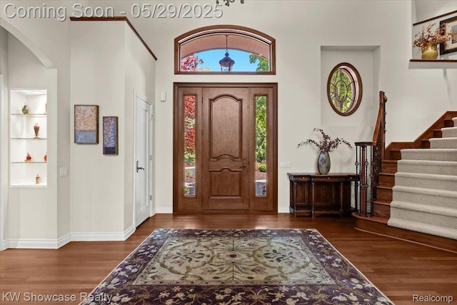 4563 Haverhill, Commerce Twp, MI 48382 - foyer entrance featuring arched walkways, wood finished floors, stairs, a towering ceiling, and baseboards