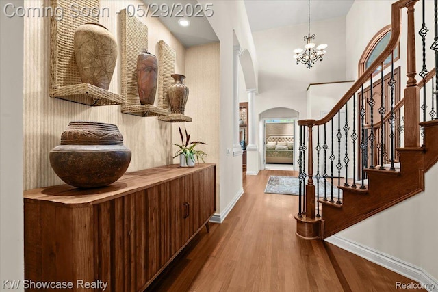 4563 Haverhill, Commerce Twp, MI 48382 - entrance foyer featuring baseboards, arched walkways, wood finished floors, ornate columns, and a chandelier
