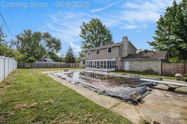 4371 E Cook Rd, Grand Blanc, MI 48439 - rear view of house featuring a sunroom, a chimney, and brick siding