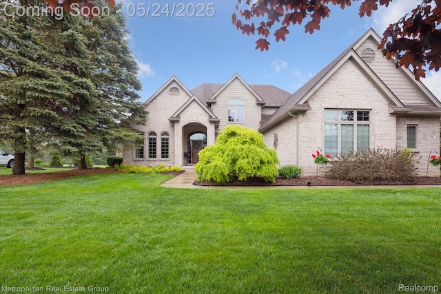 921 Gleneagles, Highland, MI 48357 - view of front facade featuring brick siding and a front lawn