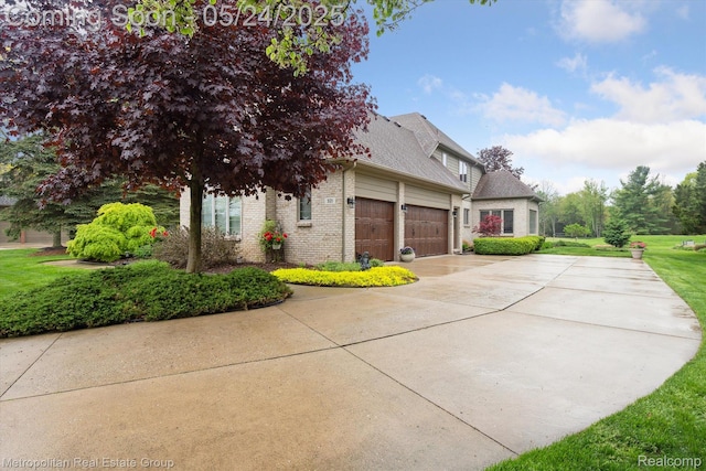 921 Gleneagles, Highland, MI 48357 - view of property exterior featuring a garage, brick siding, concrete driveway, roof with shingles, and a lawn