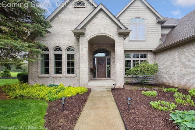 921 Gleneagles, Highland, MI 48357 - property entrance featuring brick siding and a shingled roof