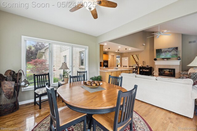 921 Gleneagles, Highland, MI 48357 - dining room featuring ceiling fan, light wood finished floors, a glass covered fireplace, and recessed lighting