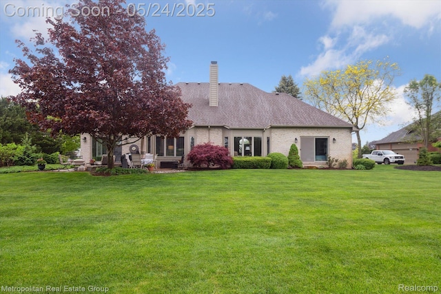 921 Gleneagles, Highland, MI 48357 - back of property with a chimney, a yard, and roof with shingles
