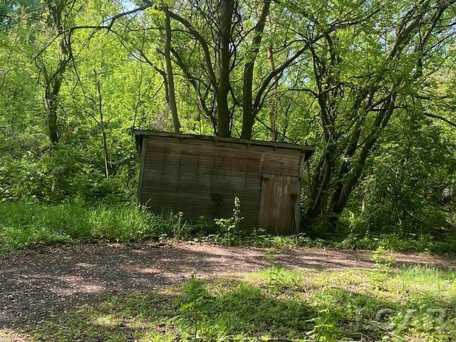 1171 S Rogers Hwy, Palmyra, MI 49268 - view of outdoor structure featuring an outbuilding and a wooded view