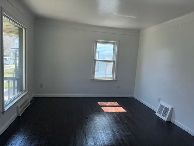 1688 S Ethel St, Detroit, MI 48217 - empty room with healthy amount of natural light, dark wood-type flooring, and baseboards