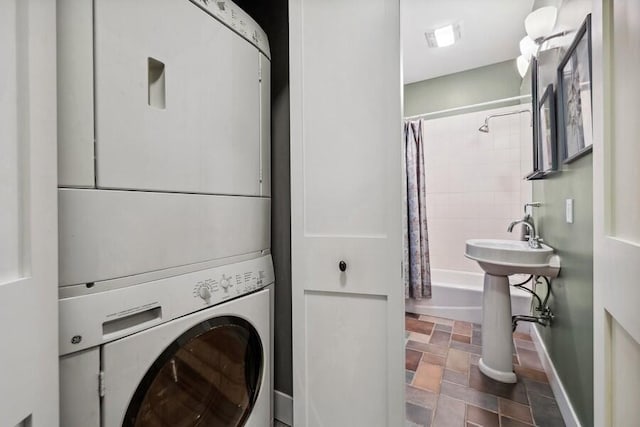 9366 E Locke Rd, Union Pier, MI 49129 - laundry room featuring stacked washer / drying machine, stone finish floors, and baseboards