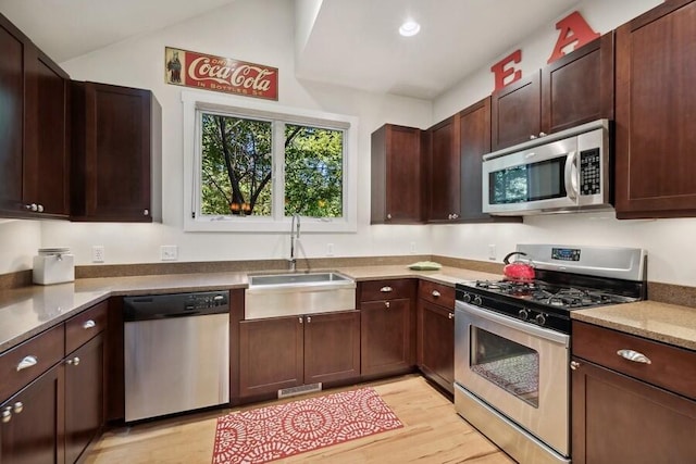 9366 E Locke Rd, Union Pier, MI 49129 - kitchen with appliances with stainless steel finishes, a sink, light wood finished floors, dark brown cabinets, and lofted ceiling