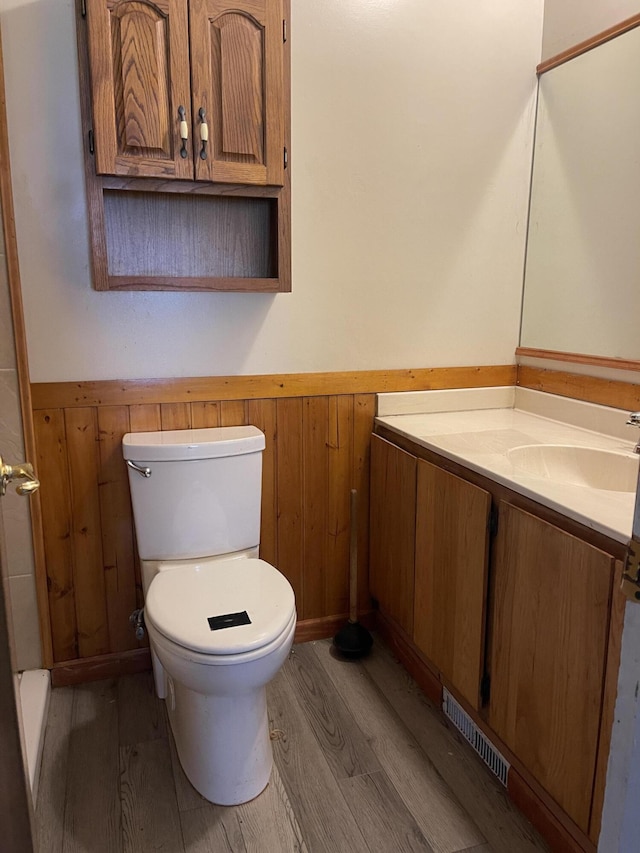 852 Maynard Ave, Jackson, MI 49202 - bathroom featuring a wainscoted wall, wood finished floors, toilet, and vanity