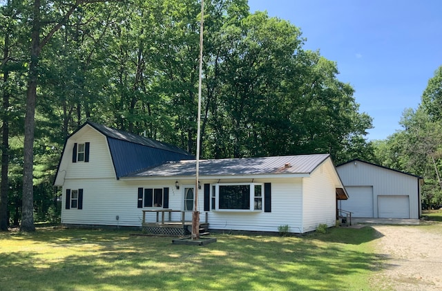 1483 W Bear Lake Rd NE, Kalkaska, MI 49646 - view of front facade featuring a garage, an outdoor structure, metal roof, and a front yard