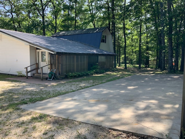 1483 W Bear Lake Rd NE, Kalkaska, MI 49646 - view of home's exterior featuring metal roof, a gambrel roof, and entry steps