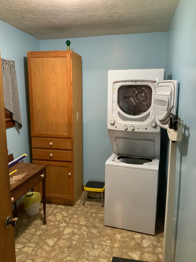 1483 W Bear Lake Rd NE, Kalkaska, MI 49646 - laundry area featuring estacked washer and dryer, light floors, and a textured ceiling