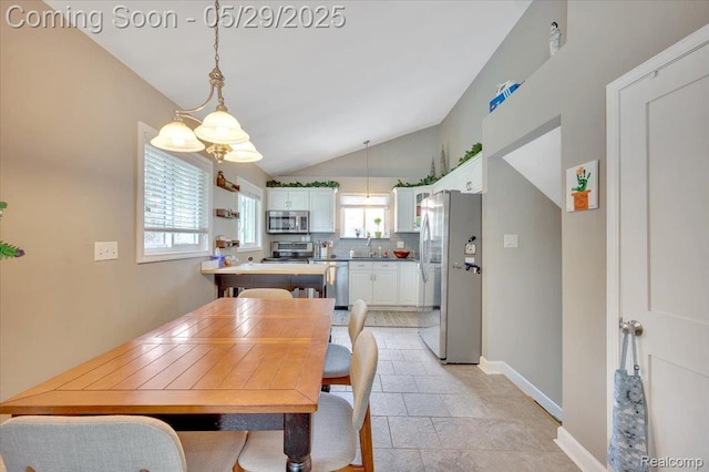 1227 Sycamore Dr, Rochester Hills, MI 48307 - dining space featuring lofted ceiling, baseboards, and light stone finish floors