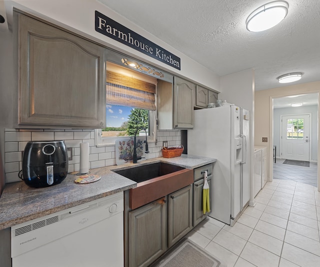 11589 Owosso Rd, Fowlerville, MI 48836 - kitchen with white appliances, light tile patterned flooring, a sink, tasteful backsplash, and a textured ceiling