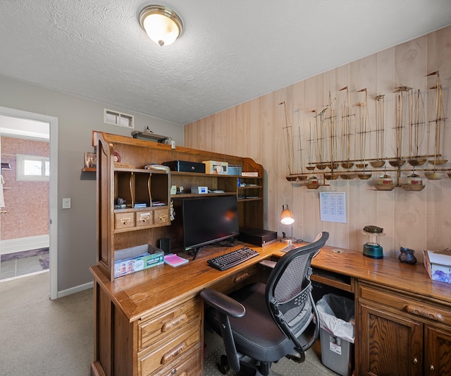 11589 Owosso Rd, Fowlerville, MI 48836 - office area featuring built in desk, wood walls, carpet flooring, baseboards, and a textured ceiling