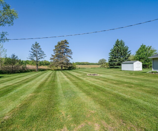 11589 Owosso Rd, Fowlerville, MI 48836 - view of grassy yard featuring a storage unit and an outbuilding