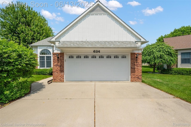 634 Eastway Cir Unit # 20, Lapeer, MI 48446 - view of front facade featuring board and batten siding, brick siding, a front lawn, and driveway