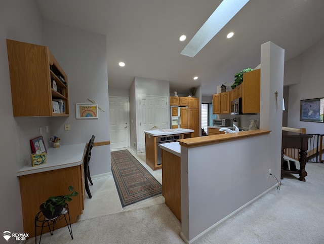 9419 Grandview Ct, Davison, MI 48423 - kitchen featuring a skylight, light colored carpet, stainless steel appliances, a peninsula, and baseboards