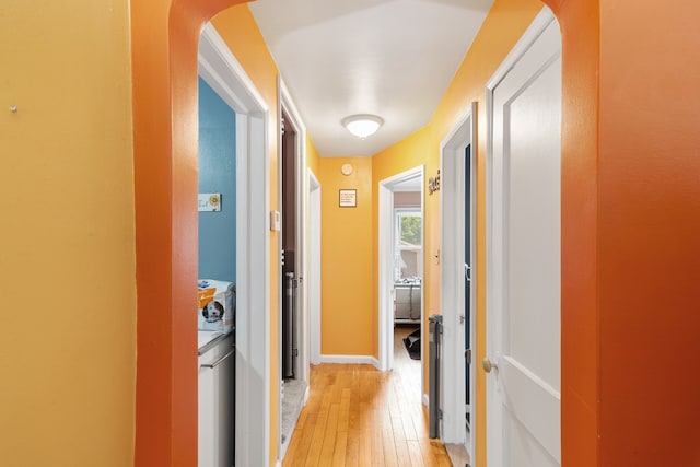 2270 23rd St, Wyandotte, MI 48192 - hall with light wood finished floors, arched walkways, washer / clothes dryer, and baseboards