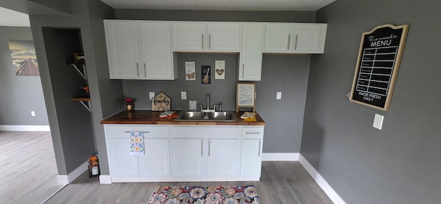 6241 Bermuda Ln, Mount Morris, MI 48458 - kitchen featuring light wood-style flooring, a sink, and baseboards