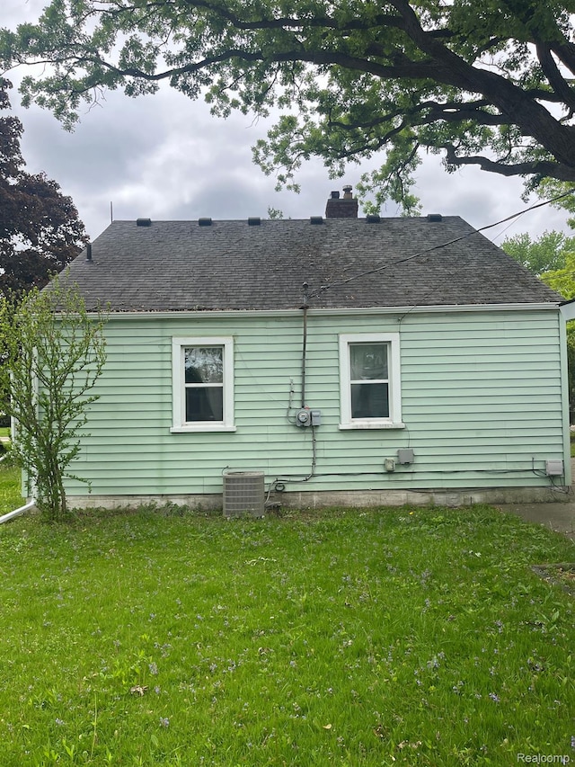 20711 Gaukler St, Saint Clair Shores, MI 48080 - rear view of house with a yard, a chimney, and roof with shingles