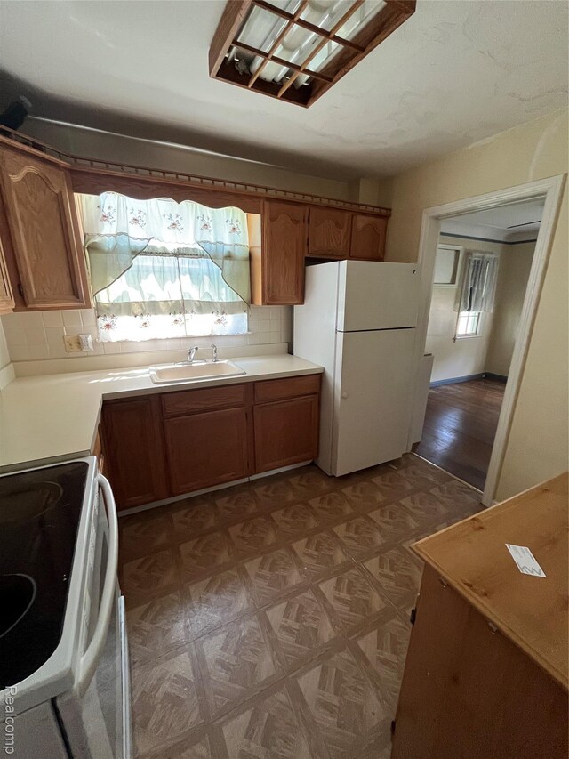 20711 Gaukler St, Saint Clair Shores, MI 48080 - kitchen featuring white appliances, plenty of natural light, light countertops, and brown cabinetry