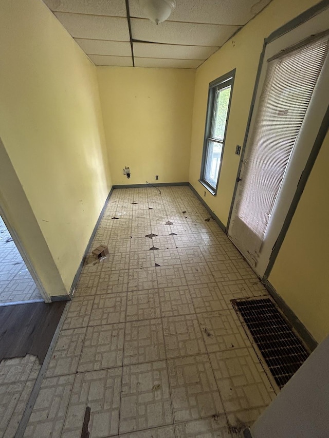 715 Avon St, Flint, MI 48503 - spare room featuring a paneled ceiling, brick patterned flooring, and baseboards