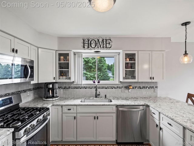 6102 Cherry Ridge Dr, Howell, MI 48855 - kitchen with appliances with stainless steel finishes, a sink, backsplash, and decorative light fixtures