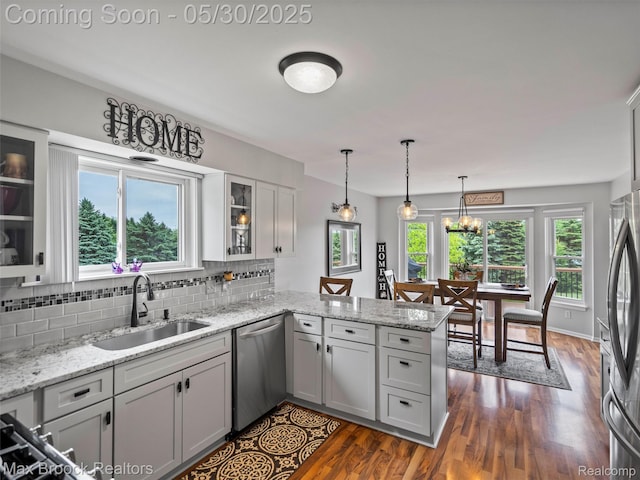 6102 Cherry Ridge Dr, Howell, MI 48855 - kitchen with appliances with stainless steel finishes, a sink, a peninsula, tasteful backsplash, and plenty of natural light