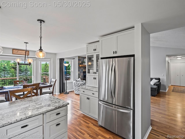 6102 Cherry Ridge Dr, Howell, MI 48855 - kitchen featuring freestanding refrigerator, wood finished floors, decorative light fixtures, and glass insert cabinets