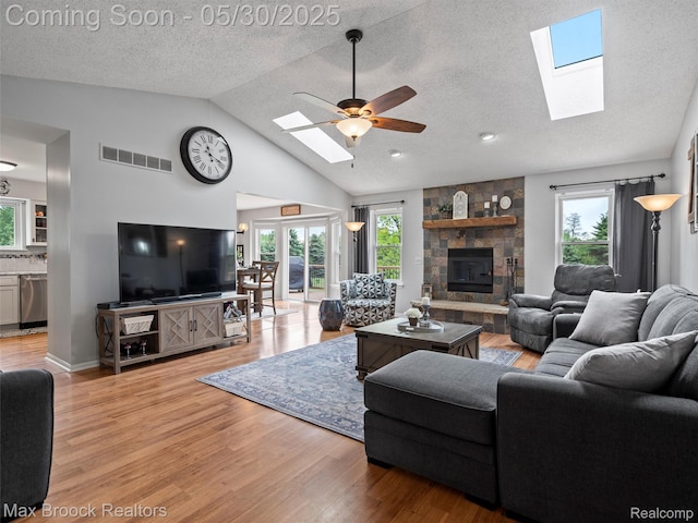 6102 Cherry Ridge Dr, Howell, MI 48855 - living room featuring a skylight, vaulted ceiling, plenty of natural light, light wood finished floors, and a ceiling fan