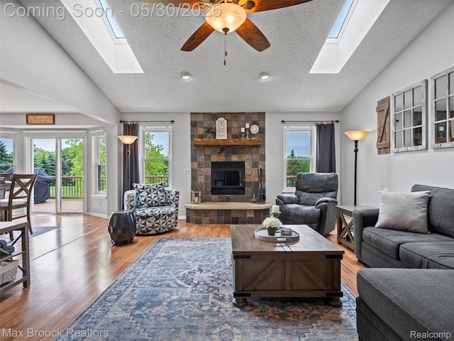 6102 Cherry Ridge Dr, Howell, MI 48855 - living room with a skylight, a ceiling fan, wood finished floors, a fireplace, and a textured ceiling
