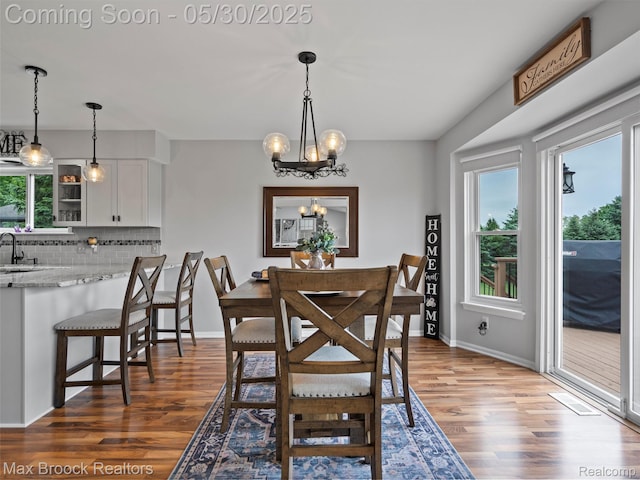 6102 Cherry Ridge Dr, Howell, MI 48855 - dining space with a chandelier, wood finished floors, and baseboards