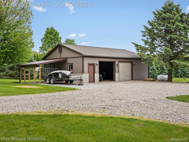 6102 Cherry Ridge Dr, Howell, MI 48855 - view of property exterior with an outdoor structure, a lawn, a garage, and a shingled roof