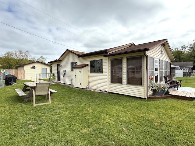 rear view of property with a wooden deck and an outdoor structure