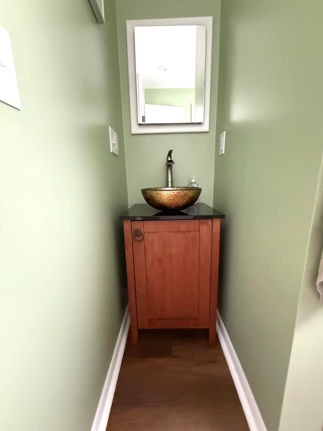 bathroom with wood finished floors, baseboards, and vanity