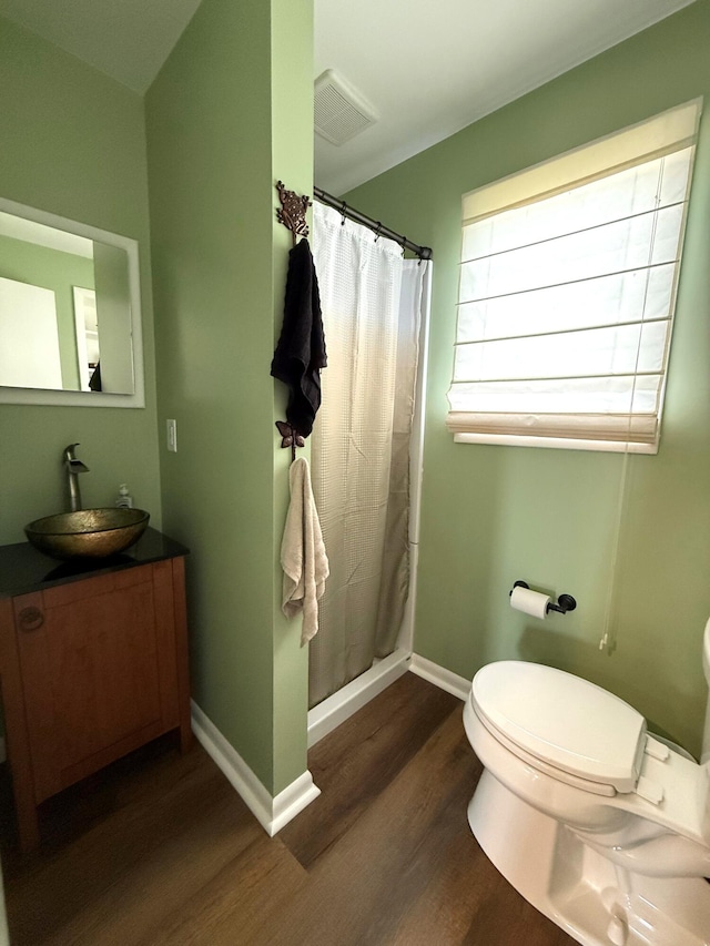 full bathroom with wood finished floors, toilet, baseboards, a shower with curtain, and vanity