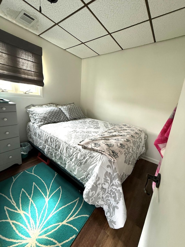 bedroom with dark wood-style flooring and a paneled ceiling