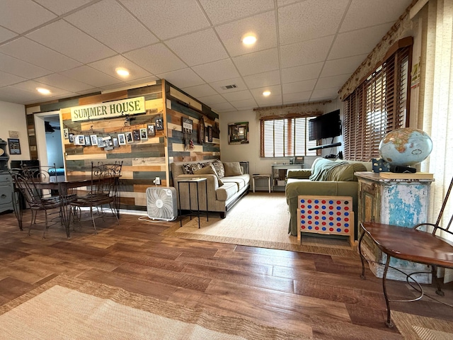 living room with wood finished floors and a drop ceiling