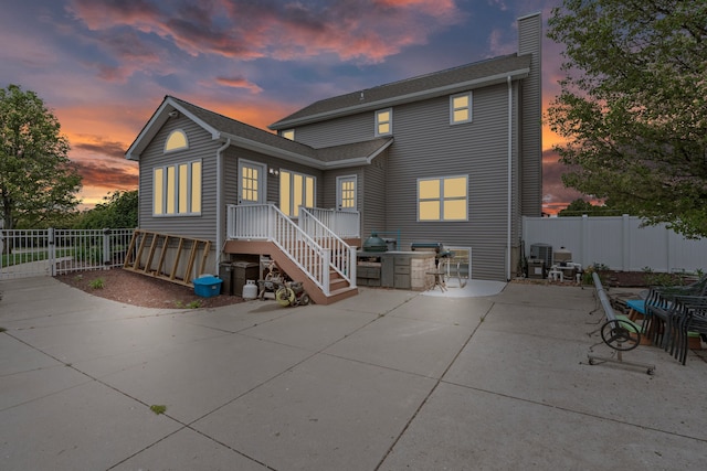 1600 Tuttle Rd, Mason, MI 48854 - back of house at dusk featuring a chimney, a patio, and cooling unit