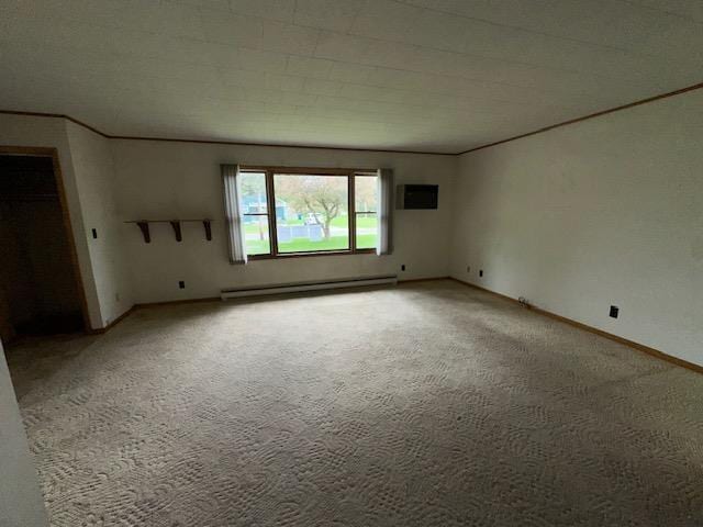 175 S Hudnut, Barryton, MI 49305 - spare room featuring a baseboard heating unit, light colored carpet, and baseboards