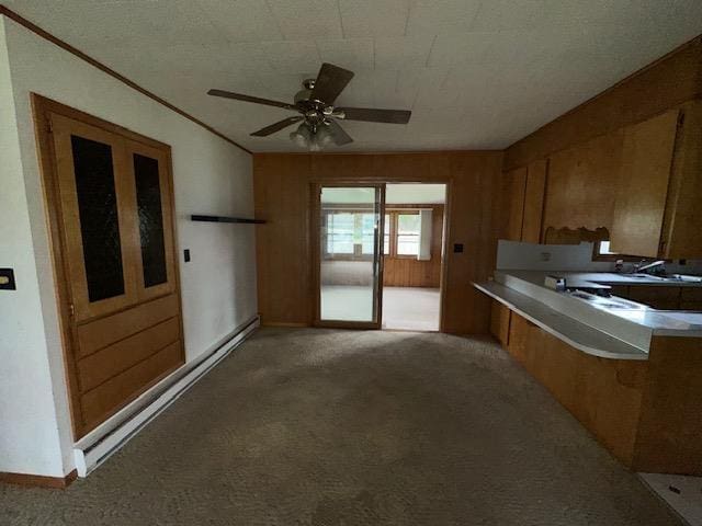 175 S Hudnut, Barryton, MI 49305 - kitchen with brown cabinetry, light colored carpet, light countertops, ceiling fan, and crown molding