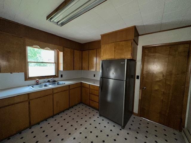 175 S Hudnut, Barryton, MI 49305 - kitchen featuring freestanding refrigerator, light flooring, a sink, and light countertops