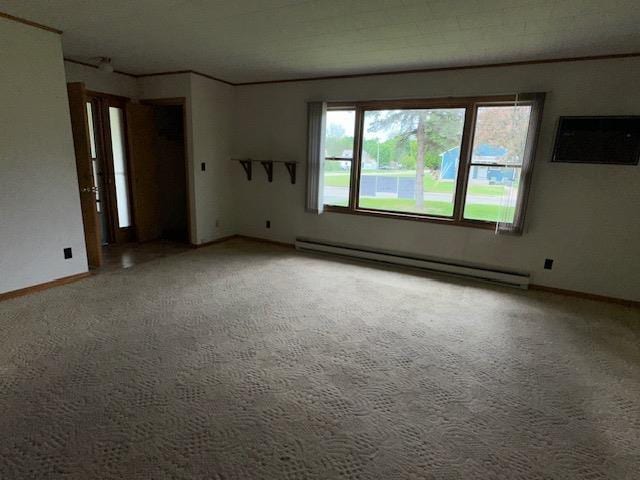 175 S Hudnut, Barryton, MI 49305 - empty room featuring a baseboard radiator, carpet, baseboards, and a wall unit AC