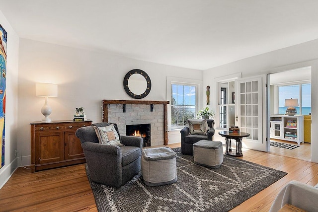 8282 W Harrison Rd, Mears, MI 49436 - living area featuring wood finished floors, a fireplace, french doors, and baseboards