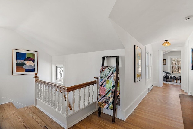 8282 W Harrison Rd, Mears, MI 49436 - hall featuring an upstairs landing, vaulted ceiling, light wood-style floors, and baseboards