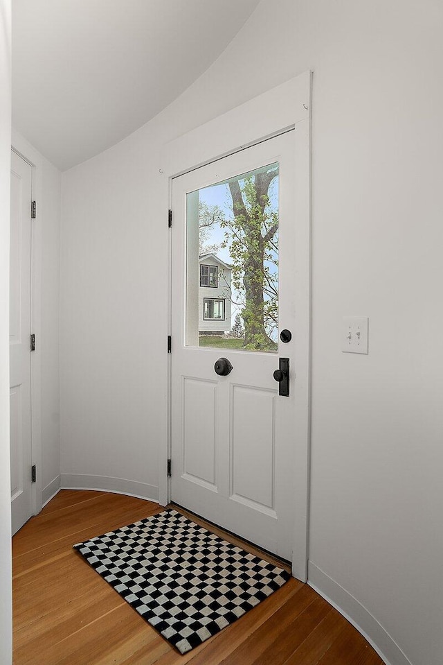 8282 W Harrison Rd, Mears, MI 49436 - doorway to outside featuring wood finished floors, baseboards, and lofted ceiling