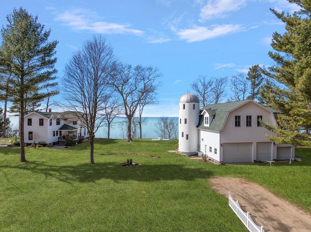 8282 W Harrison Rd, Mears, MI 49436 - view of green lawn with dirt driveway, a water view, and a detached garage